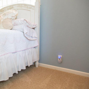 Pest Repeller Ultimate® AT plugged into an outlet in the bedroom